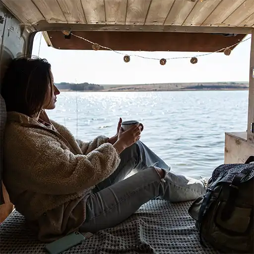 Wohnmobil steht malerisch an einem Seeufer, umgeben von klarer Wasseroberfläche, grüner Natur und friedlicher Atmosphäre – perfekter Ort für Erholung und Camping am Wasser.